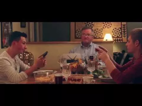С мобильным телефоном за обеденным столом